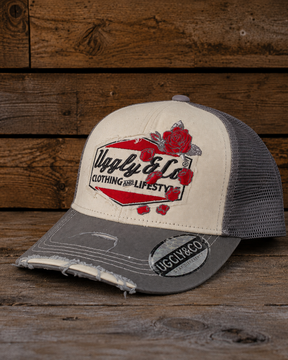 front view of the Rose Diamond Cap with Uggly&Co branding, red rose details, cream and grey panels, and a worn vintage-style curved peak. Trucker hat