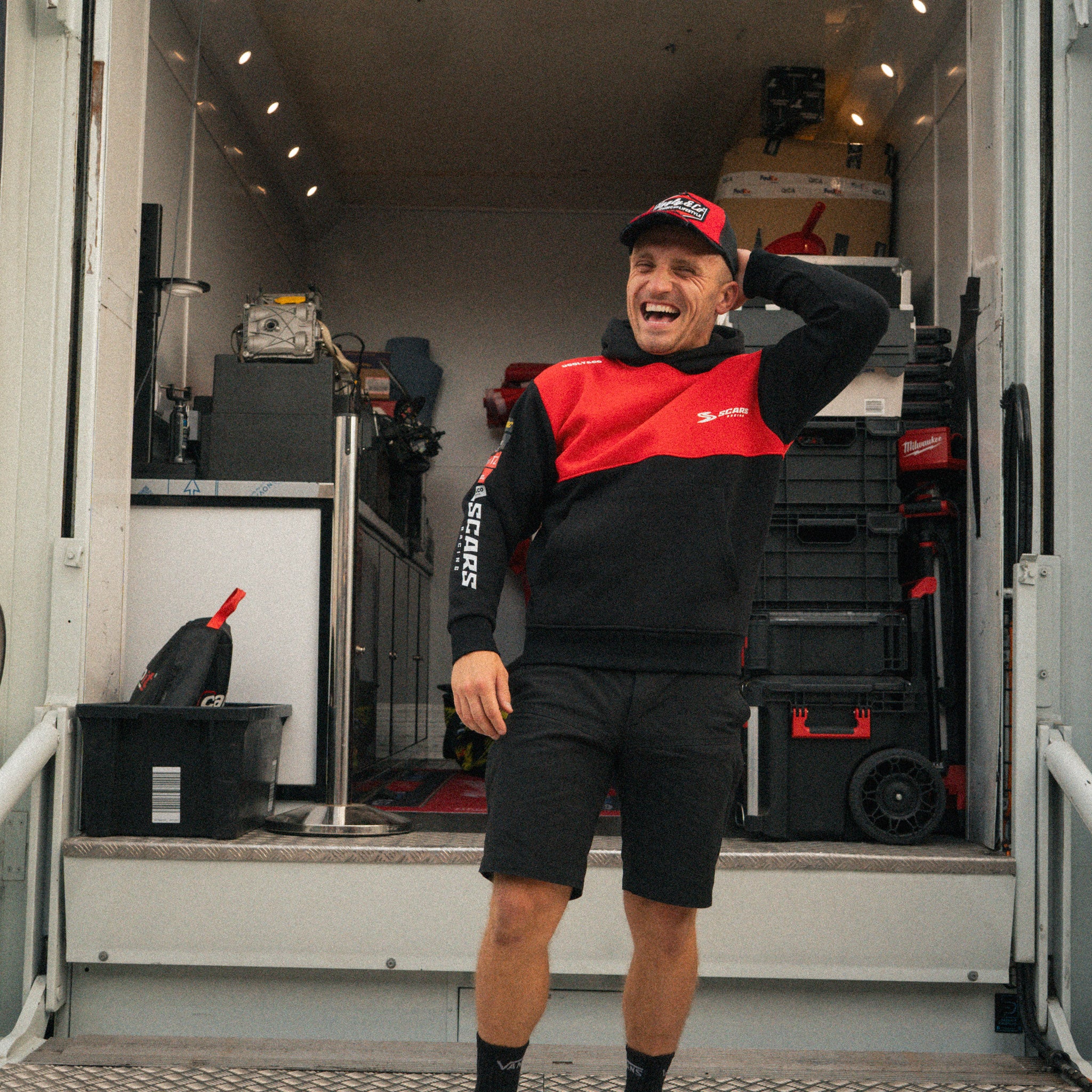 Luke Stapleford wearing a black Scars Racing hoodie in the garage