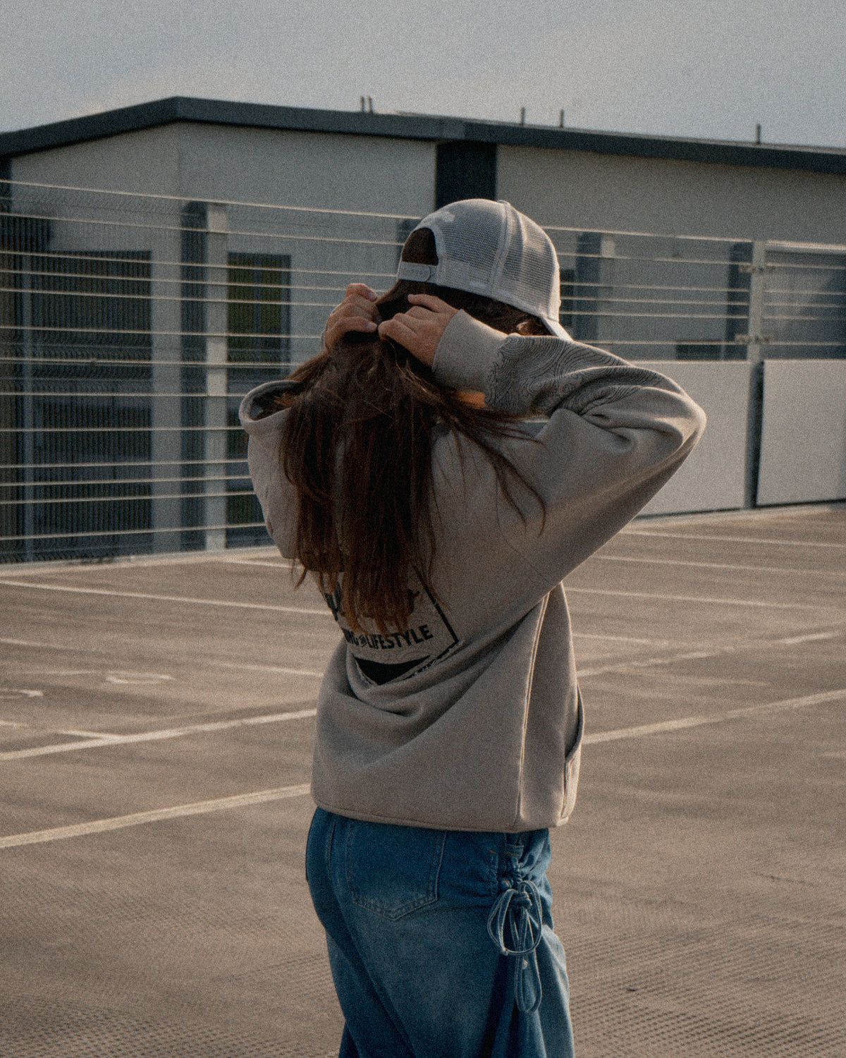 Side profile of a female model wearing the Silver & Grey Diamond Trucker Hat