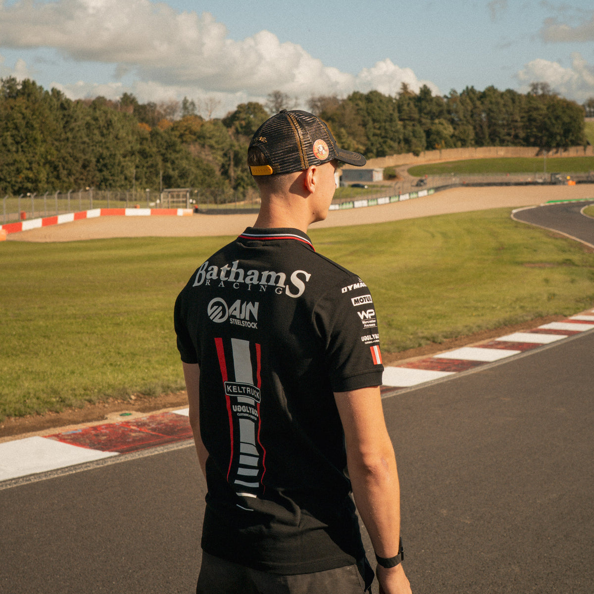 Storm Stacey wearing the Bathams Racing x AJN Steelstock Road Racing Polo from a three-quarter angle