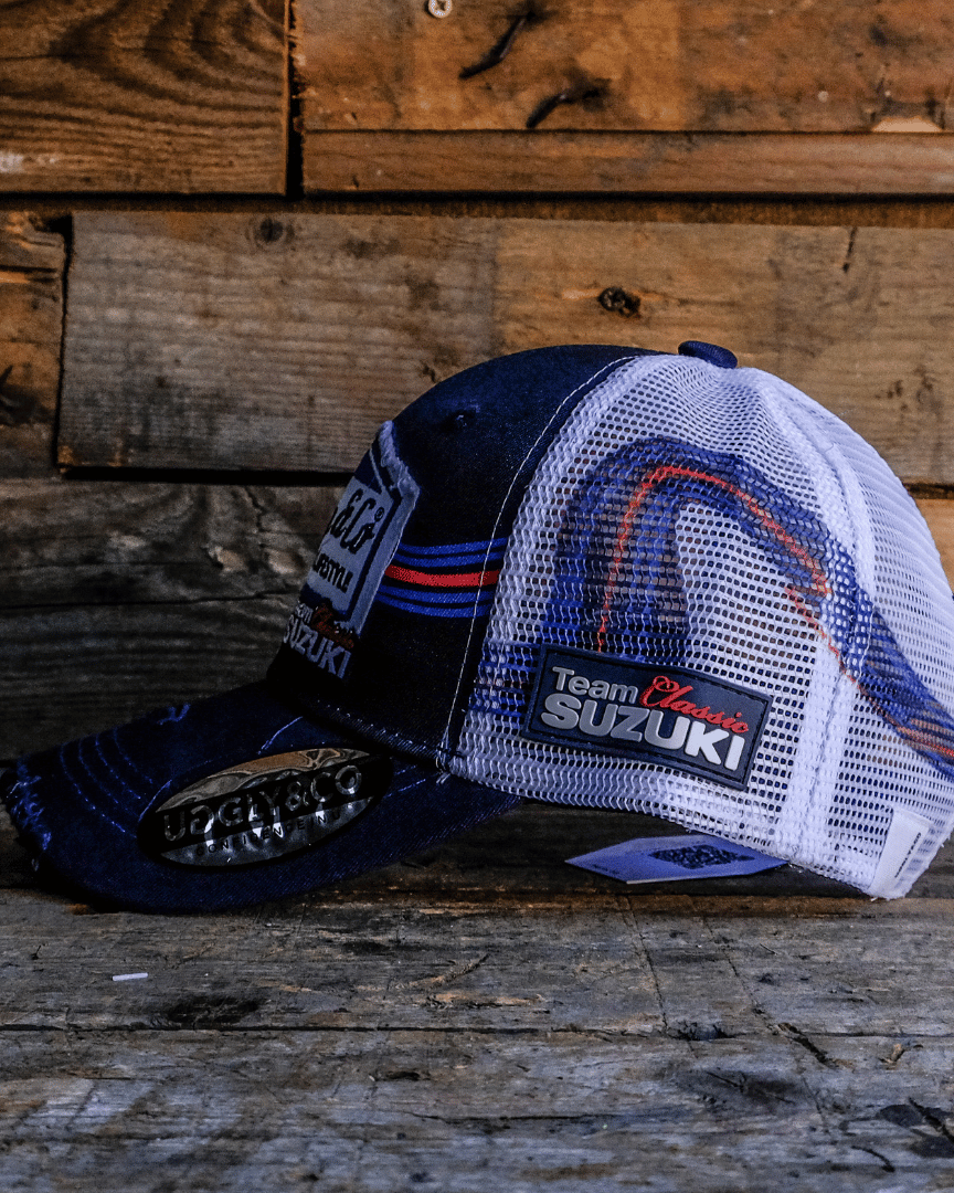 Side view of a Team Classic Suzuki trucker hat on blue, red and white, with a mesh back and an Uggly&Co diamond logo on the front