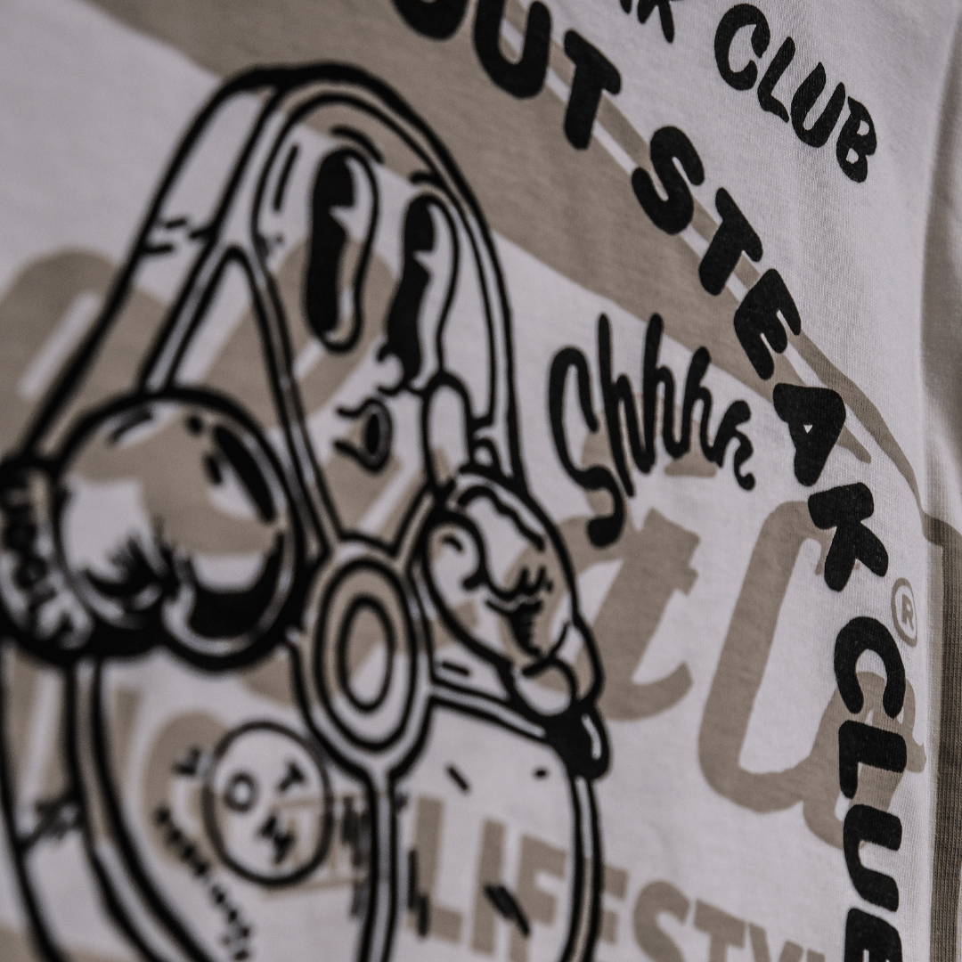 Close up of the rear logo on a Tom Kerridge's Butchers Tap and Grill white t-shirt with black graphics and text