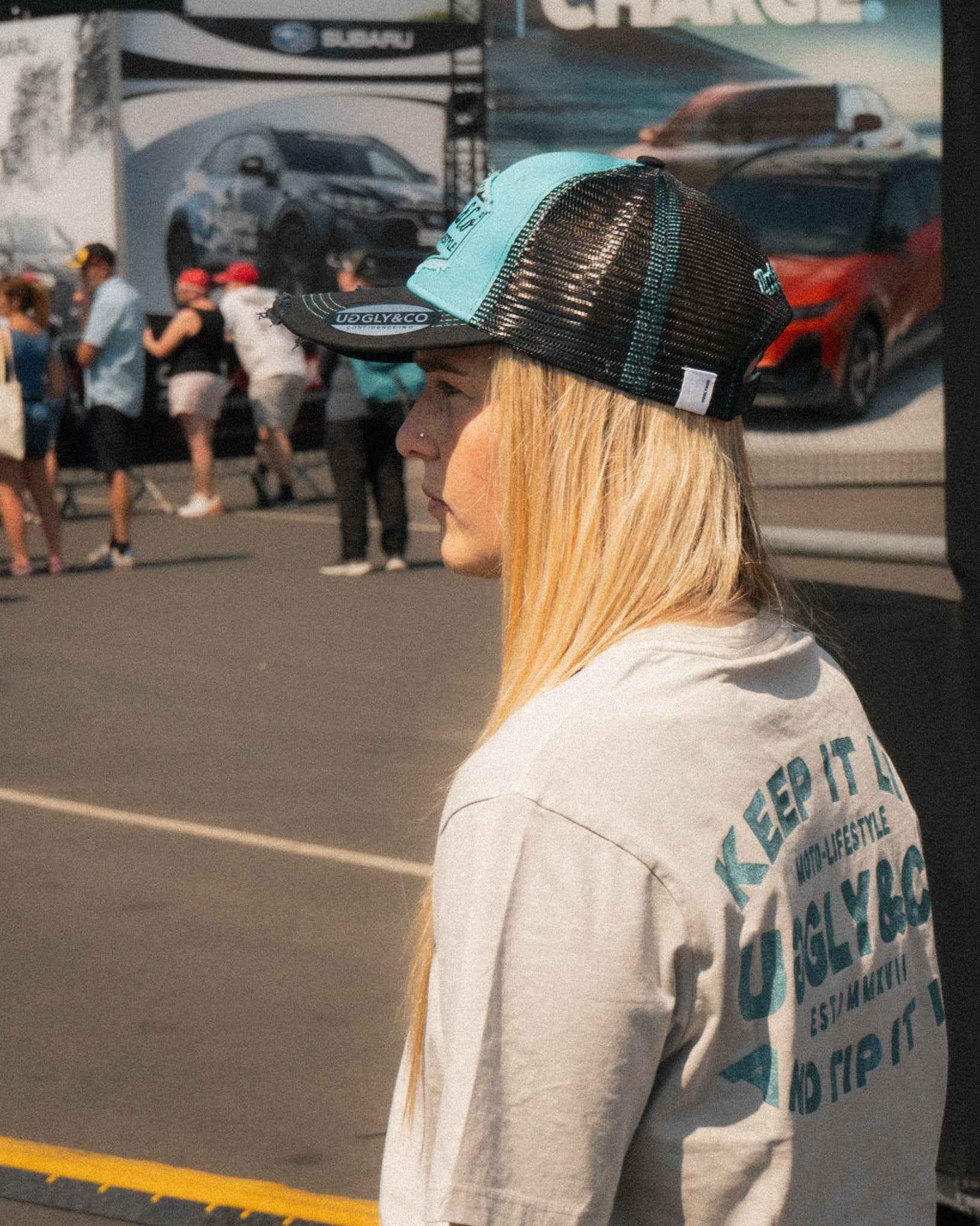 Chloe Jones wearing the Turquoise and Black Diamond Cap with a casual motorsport look