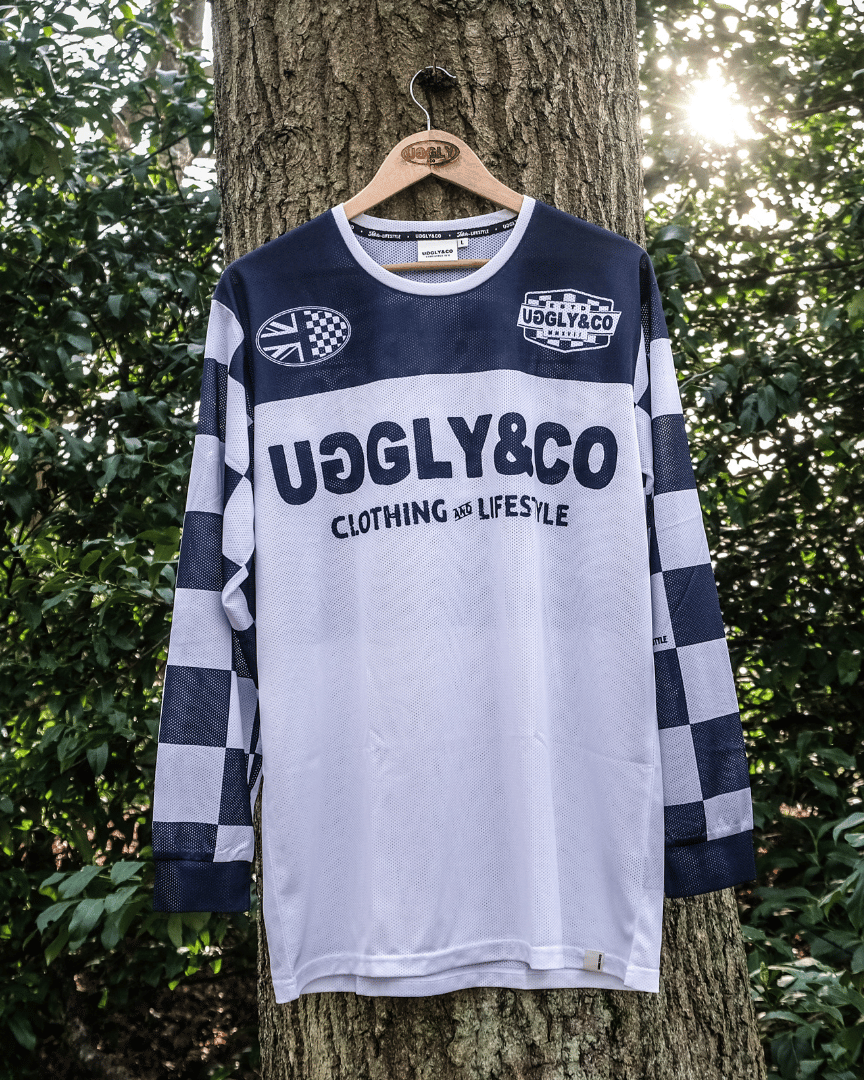 Forwards facing checkered long-sleeve MX shirt with an Uggly&Co brand logo hanging on a tree