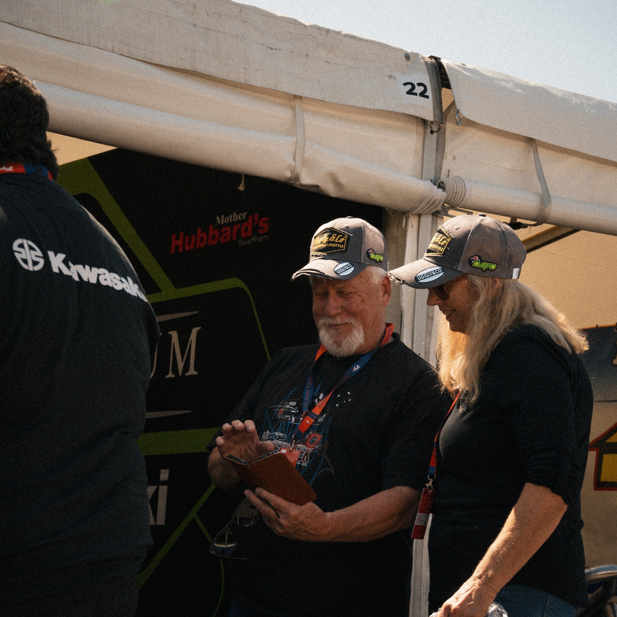 two tt fans in the paddock wearing davo Johnson trucker hats