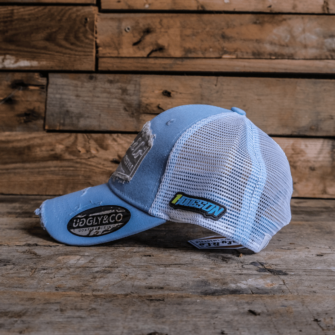 Blue and white trucker hat side view with visible branding on a wooden background