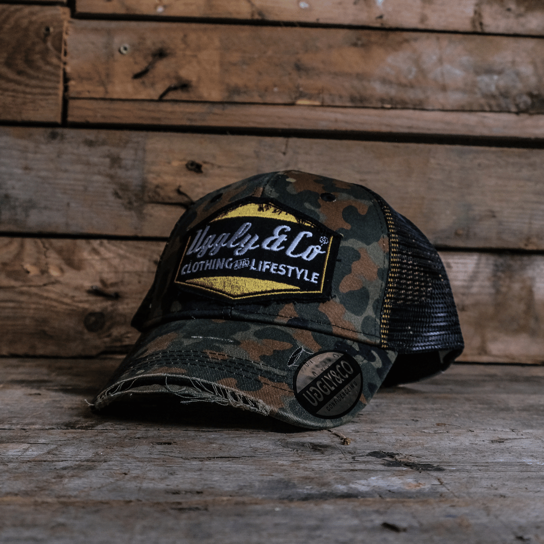 Camouflage trucker hat with the Uggle&Co patch on a wooden background