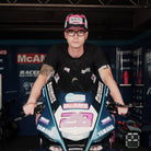Bradley Ray seen wearing a pink black and white trucker hat whilst sat on his mcams bike