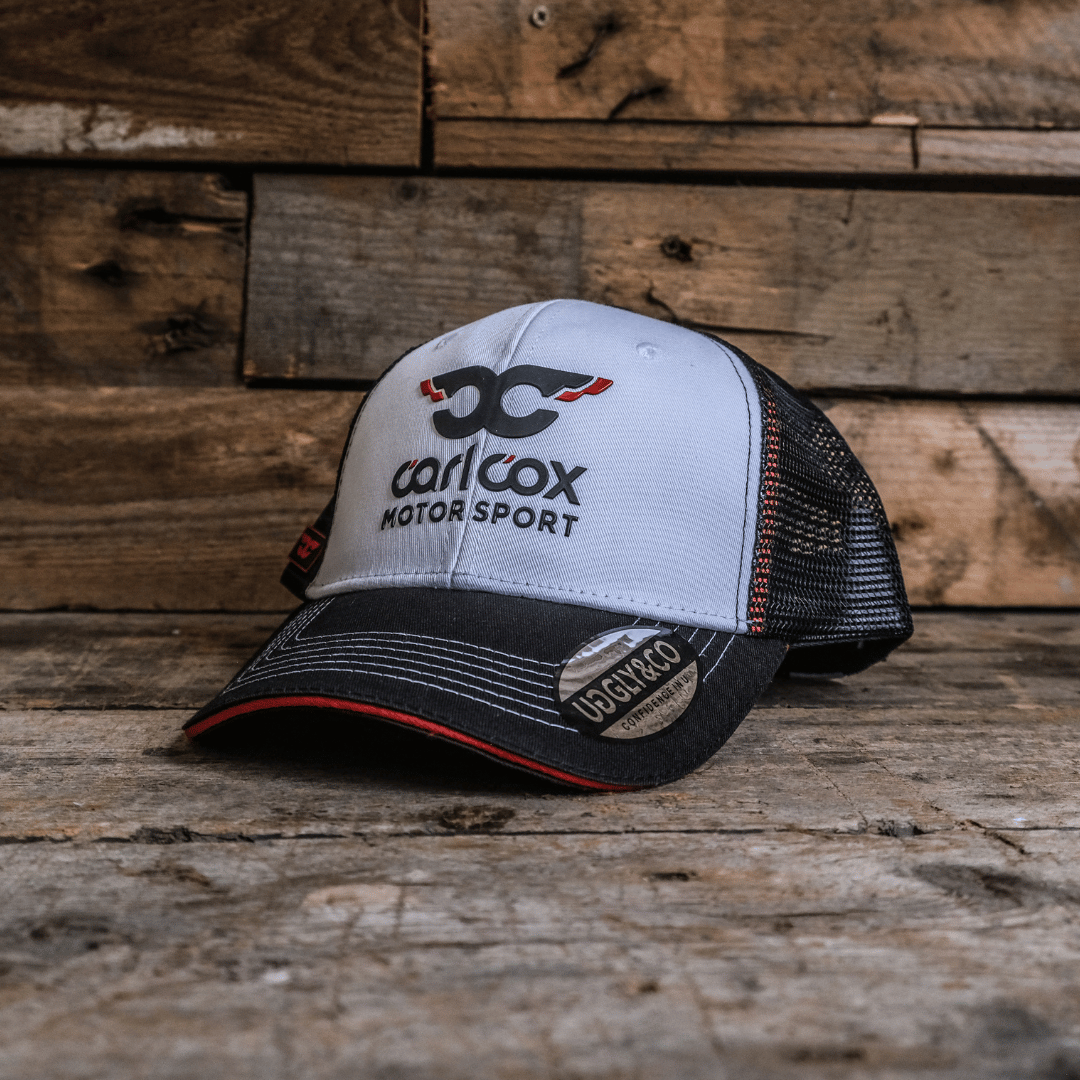 A black and white baseball cap with the Carl Cox Motorsport logo on the front.