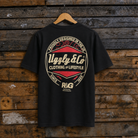 Black t-shirt with a red and white logo on a wooden background