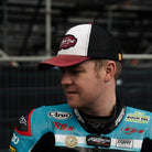 Dan Ingham in black dub hat by race stands side profile