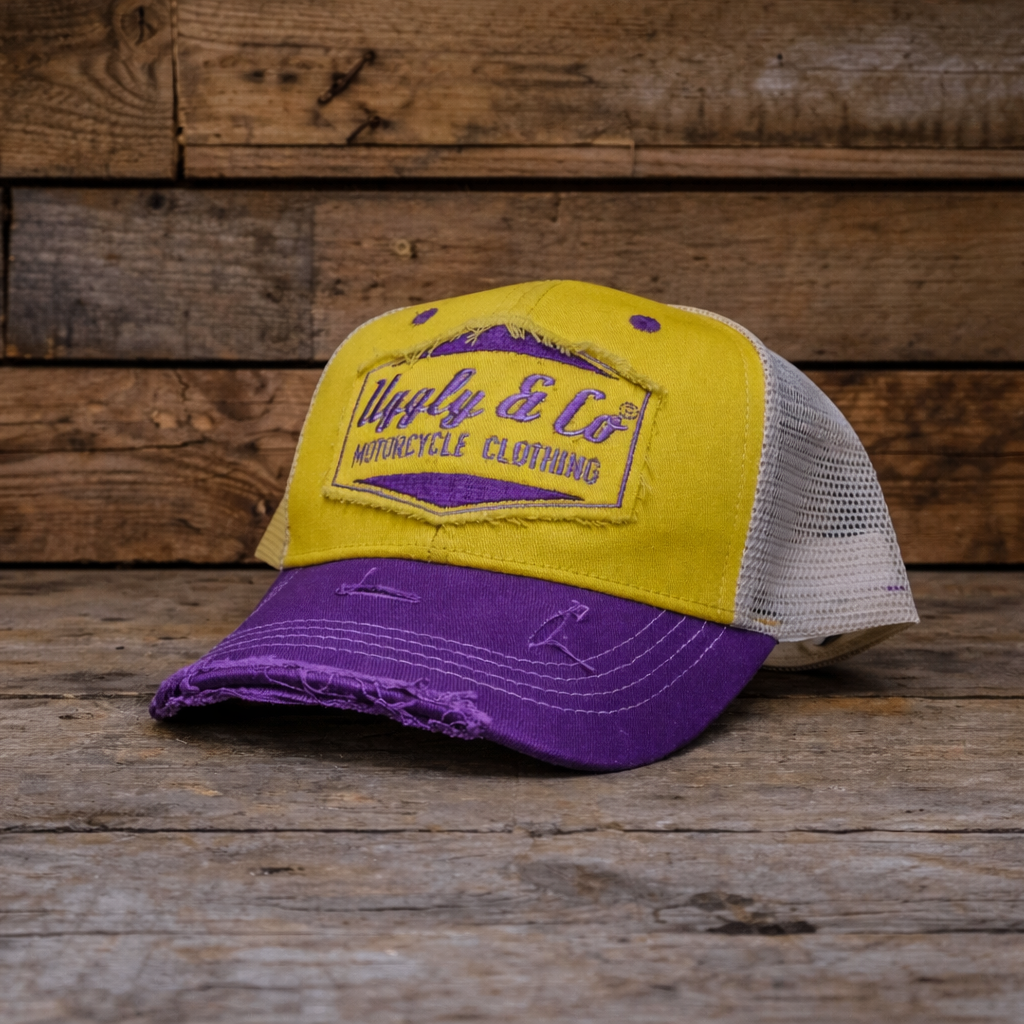 Yellow and purple cap with a brand logo on a wooden background
