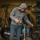 man working on vintage motorbiek wearing blue beanie and acid wash hoodie
