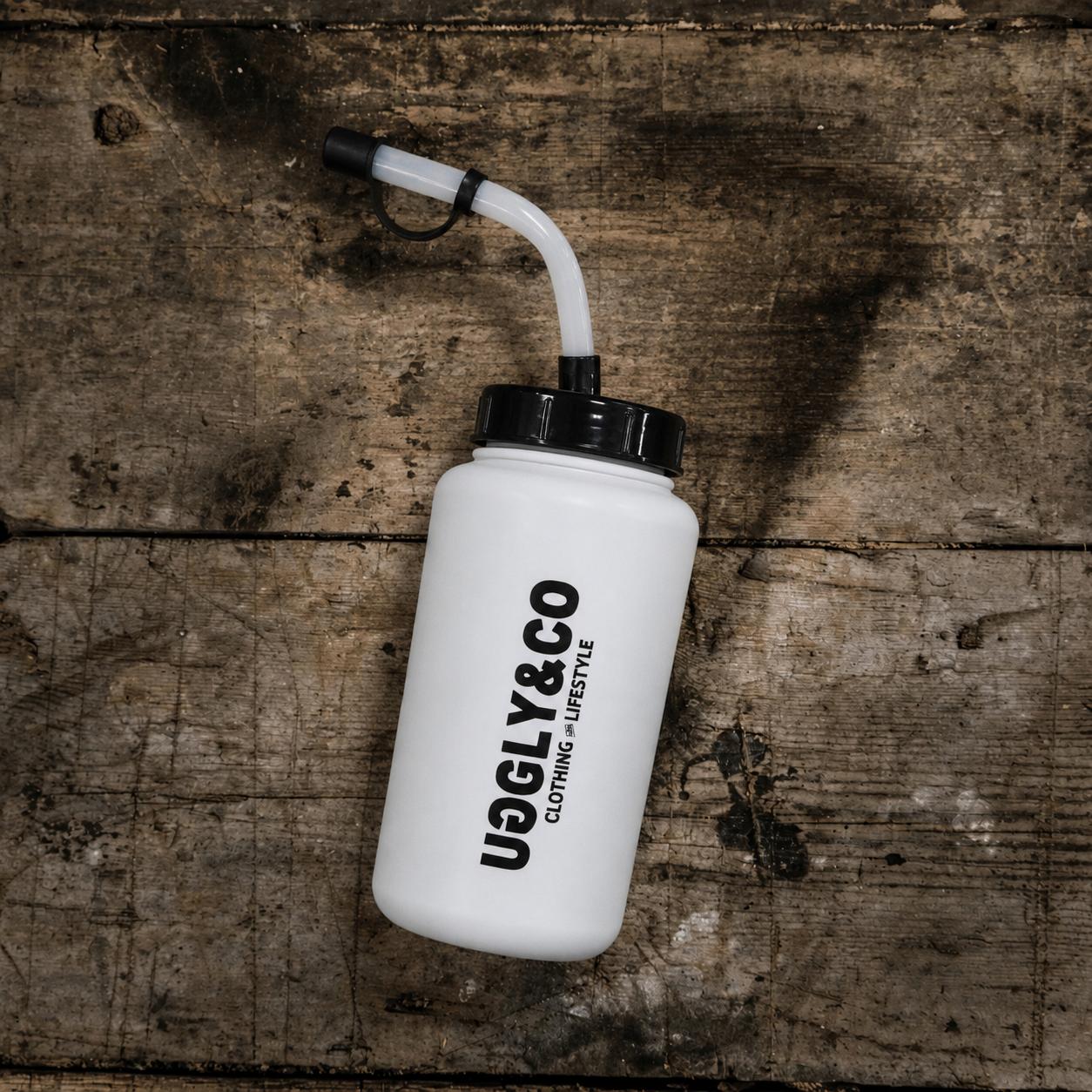 White water bottle with black cap and 'Uggly&Co' branding on a wooden surface
