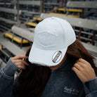 close up shot of a girl wearing a blue cap at a motorsport race