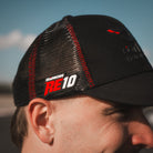 Side profile of the Carl Cox x Alpha Racing & Simon Reid Trucker Hat, showcasing its Simon Reid logo