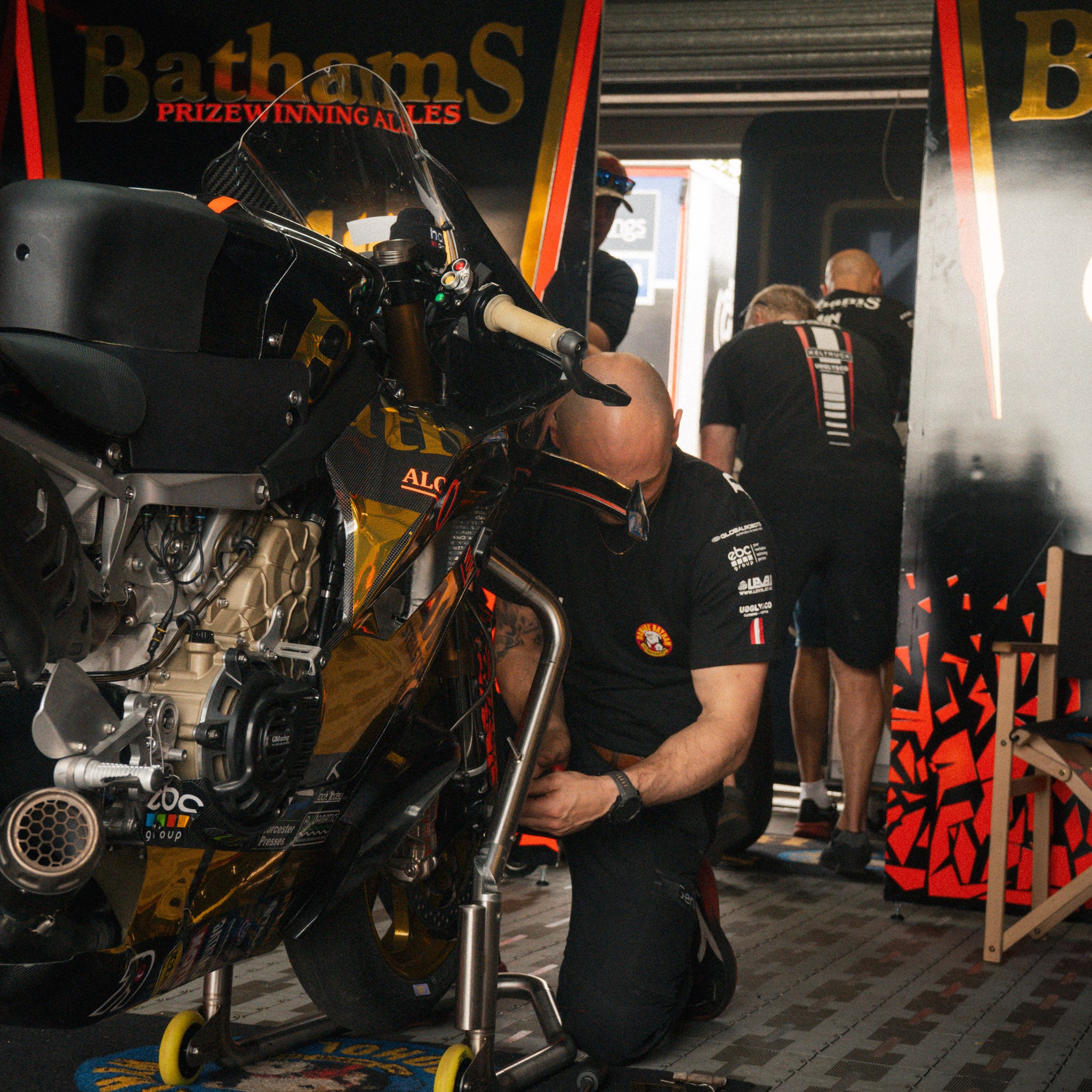 Bathams Racing x AJN Steelstock T-Shirt worn by team mechanics inside the garage at a race meeting