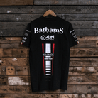 Rear view of a Banthams Racing branded black t-shirt with racing sponsor logos on a wooden background
