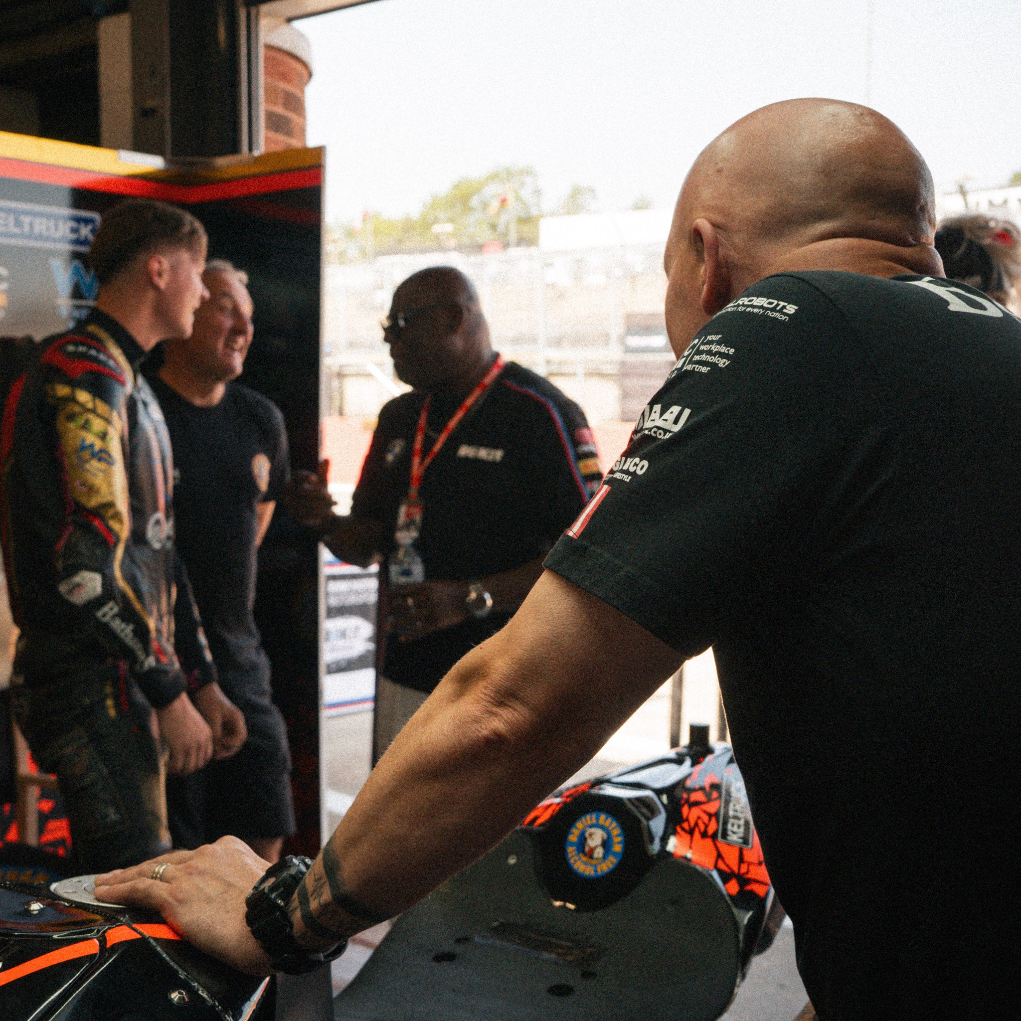 Bathams Racing mechanics wearing matching road racing T-shirts while working in the team garage