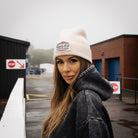 beige Diamond beanie worn by a female model in a motorsport pit lane setting