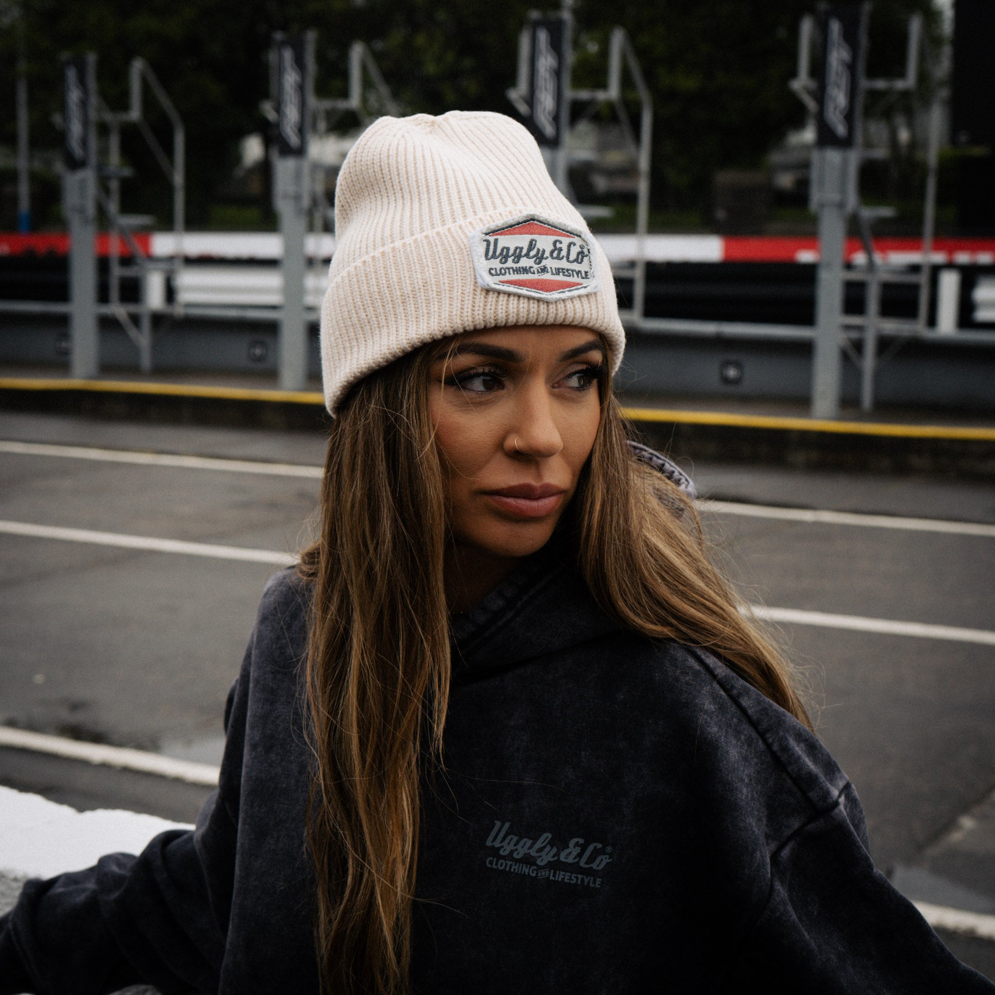 Uggly&Co beige Diamond Beanie worn by a female model in the TT paddock