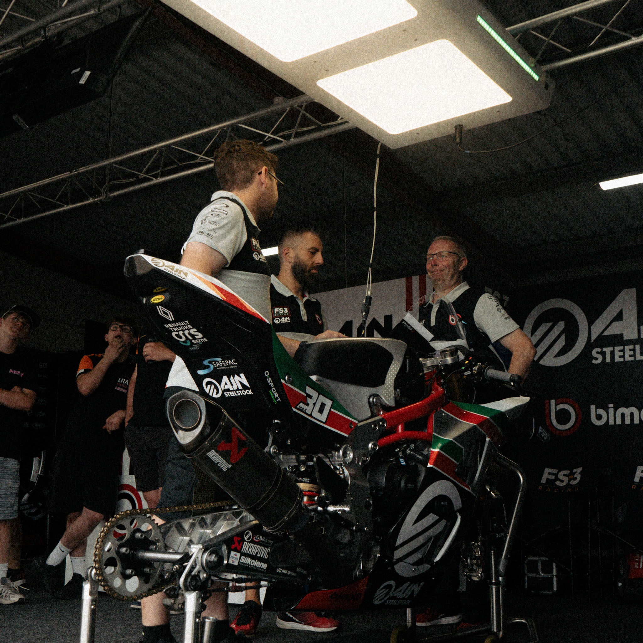 Bimota FS-3 team wearing British Superbikes Polo Shirts inside the race garage.