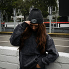 Girl model wearing a black Diamond beanie while standing in the pit lane
