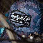 Blue camouflage trucker cap featuring Uggly & Co diamond branding