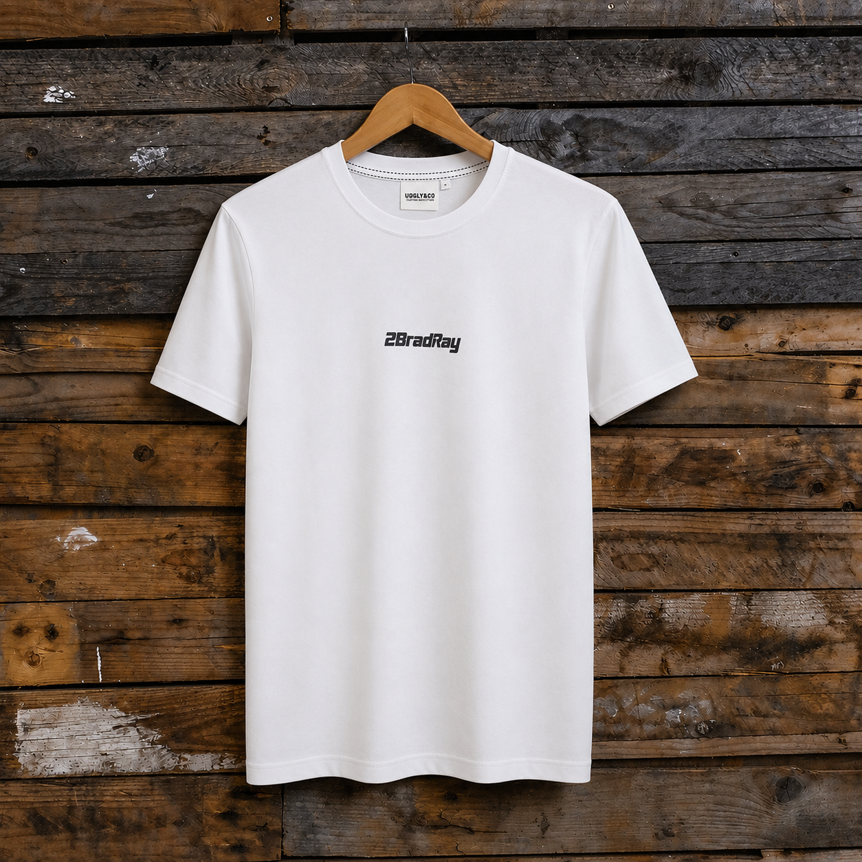 Front view of a Bradley Ray signature take the risk white t-shirt on a wooden background