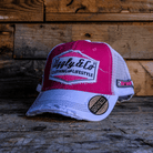 Bradley Ray branded pink and white cap with Uggly&Co diamond logo on the front on a wooden background