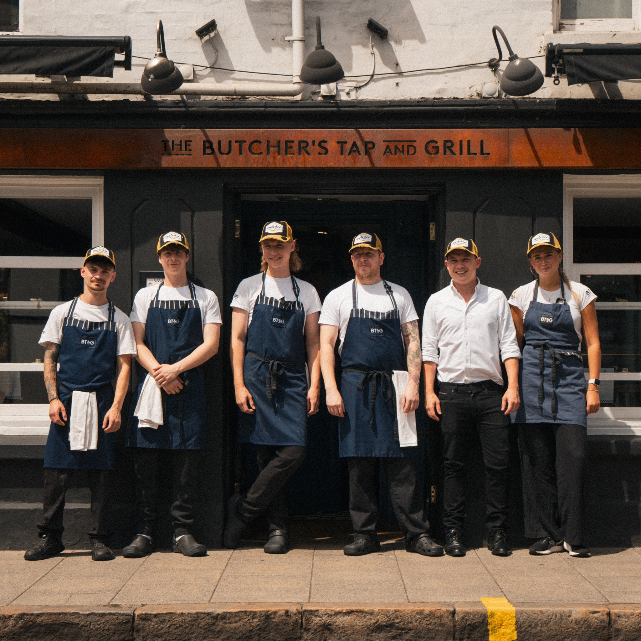 Butchers Tap restaurant staff wearing branded caps