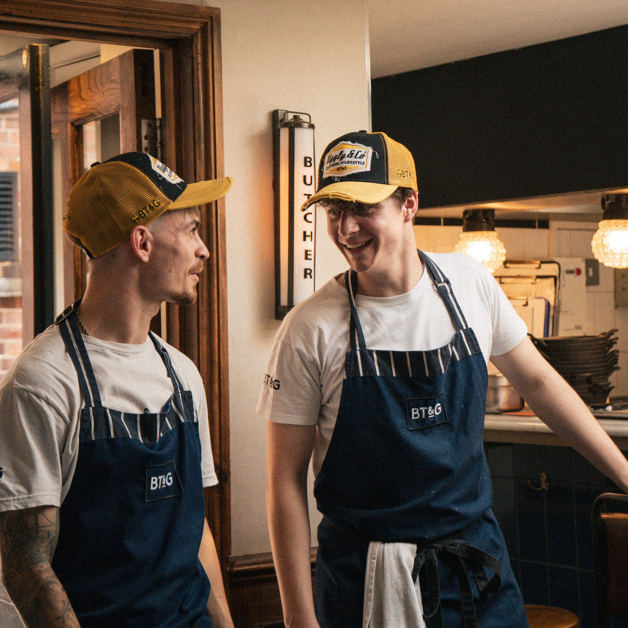 Butchers Tap chefs wearing matching branded caps in the restaurant kitchen.