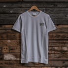 Front view of a Tom Kerridge's Butchers Tap and Grill white t-shirt with black graphics and text on a wooden background