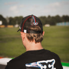 Close-up of the Carl Cox Trucker Hat collaboration design featuring Alpha Racing and Simon Reid branding, part of the Uggly & Co motorcycle lifestyle collection.
