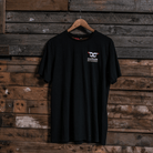 Front view of a Carl Cox Motorsport BPM RPM black t-shirt on a wooden background