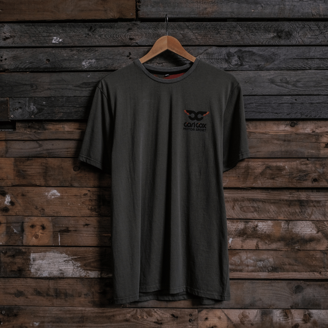 Front view of a Carl Cox Motorsport BPM RPM green t-shirt on a wooden background