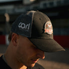 Carl Cox Motorsport Cup Cap photographed trackside at Donington Park, showcasing motorcycle racing merchandise inspired by British Superbikes and Carl Cox Motorsport.