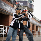 Female model in a Carl Cox Motorsport track jacket at a live racing event.