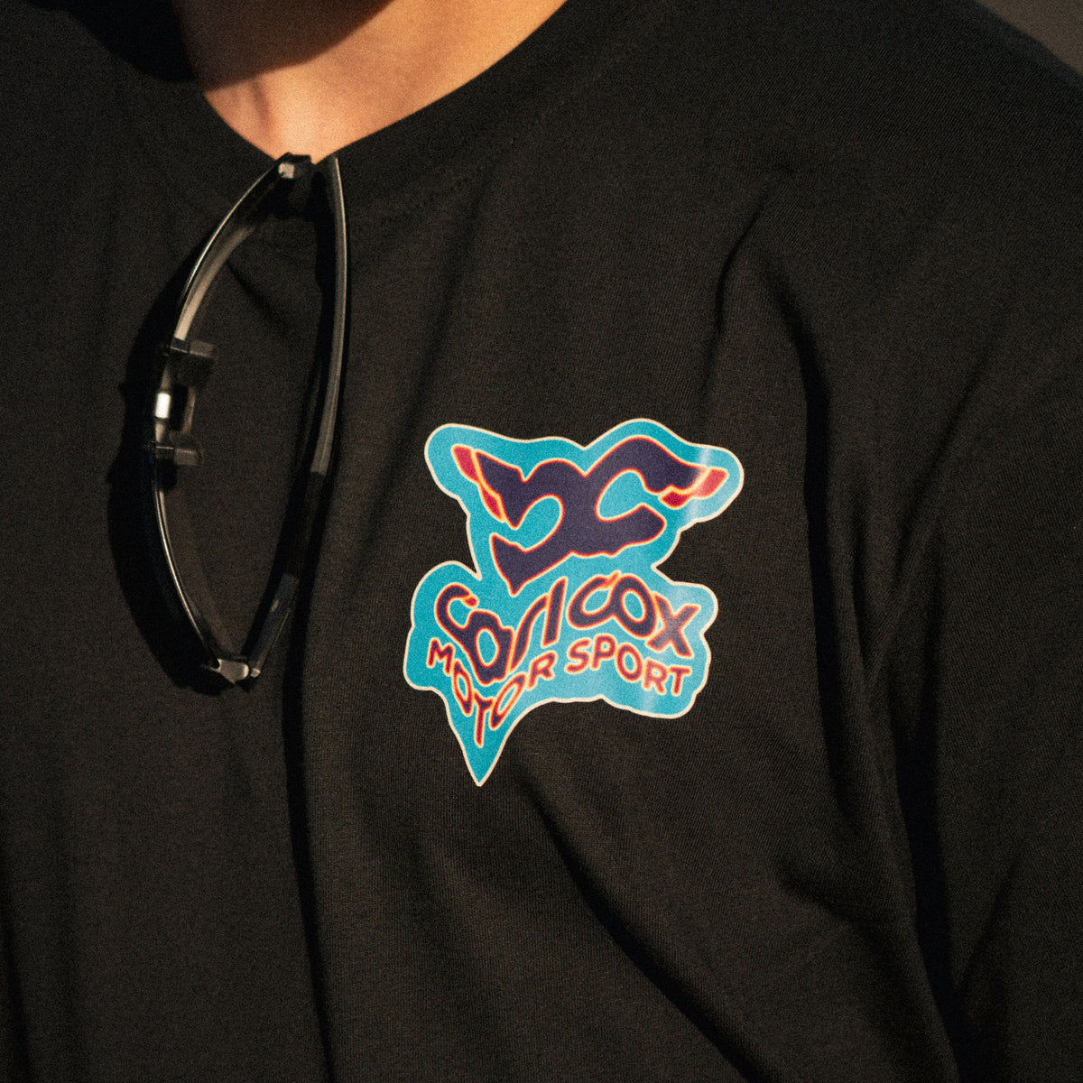 Close-up of the Carl Cox Motorsport Neon Street Drive T-Shirt graphic, highlighting the neon motorsport design and racing inspired details.