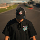 British Superbike racer Simon Reid pictured wearing the Carl Cox Motorsport Neon Street Drive Tee at Donington Park, showcasing Carl Cox motorcycle racing merchandise.