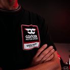 Close up of the chest logo on a Carl Cox motorsport black t-shirt with an Uggly&Co logo