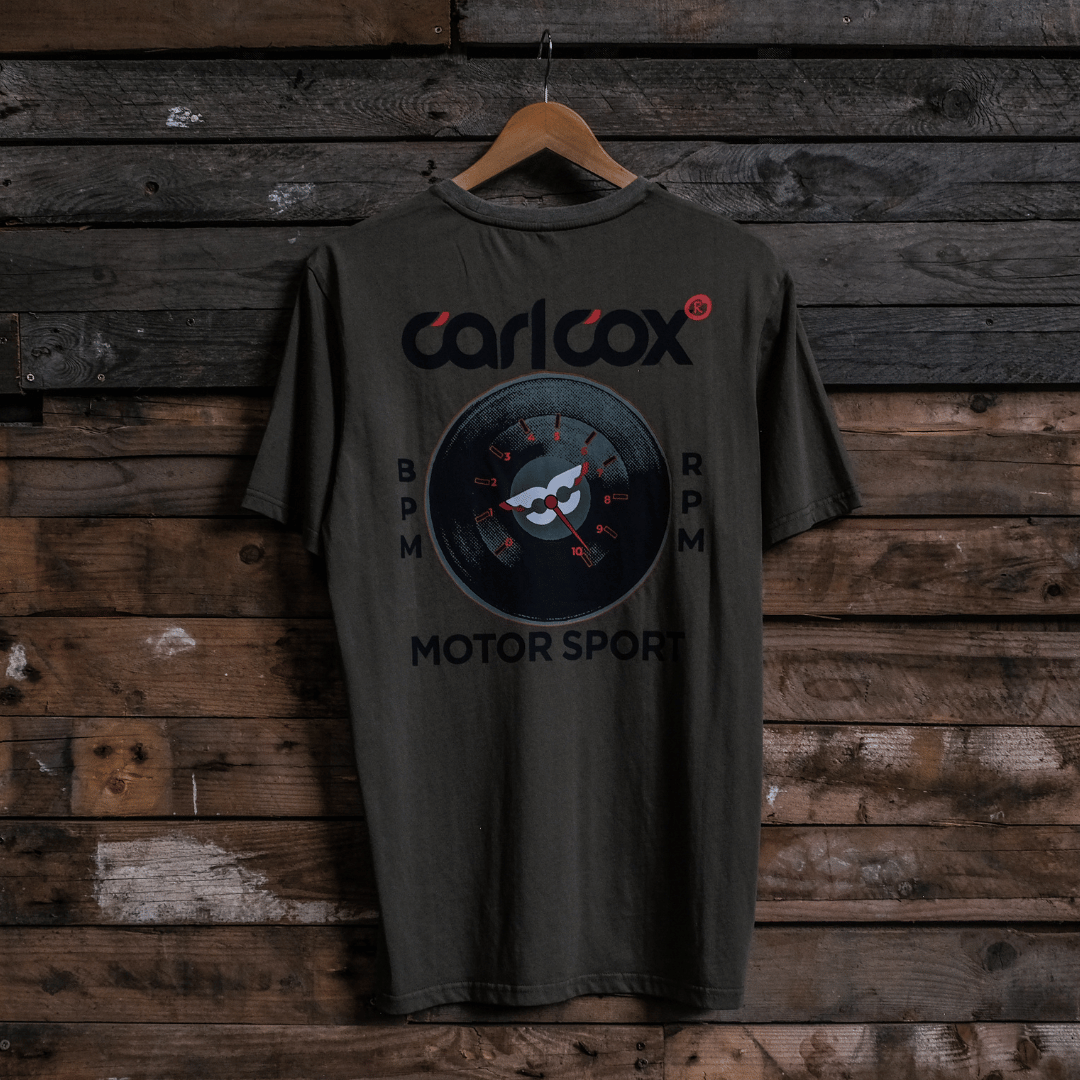 Rear view of a Carl Cox Motorsport BPM RPM green t-shirt on a wooden background
