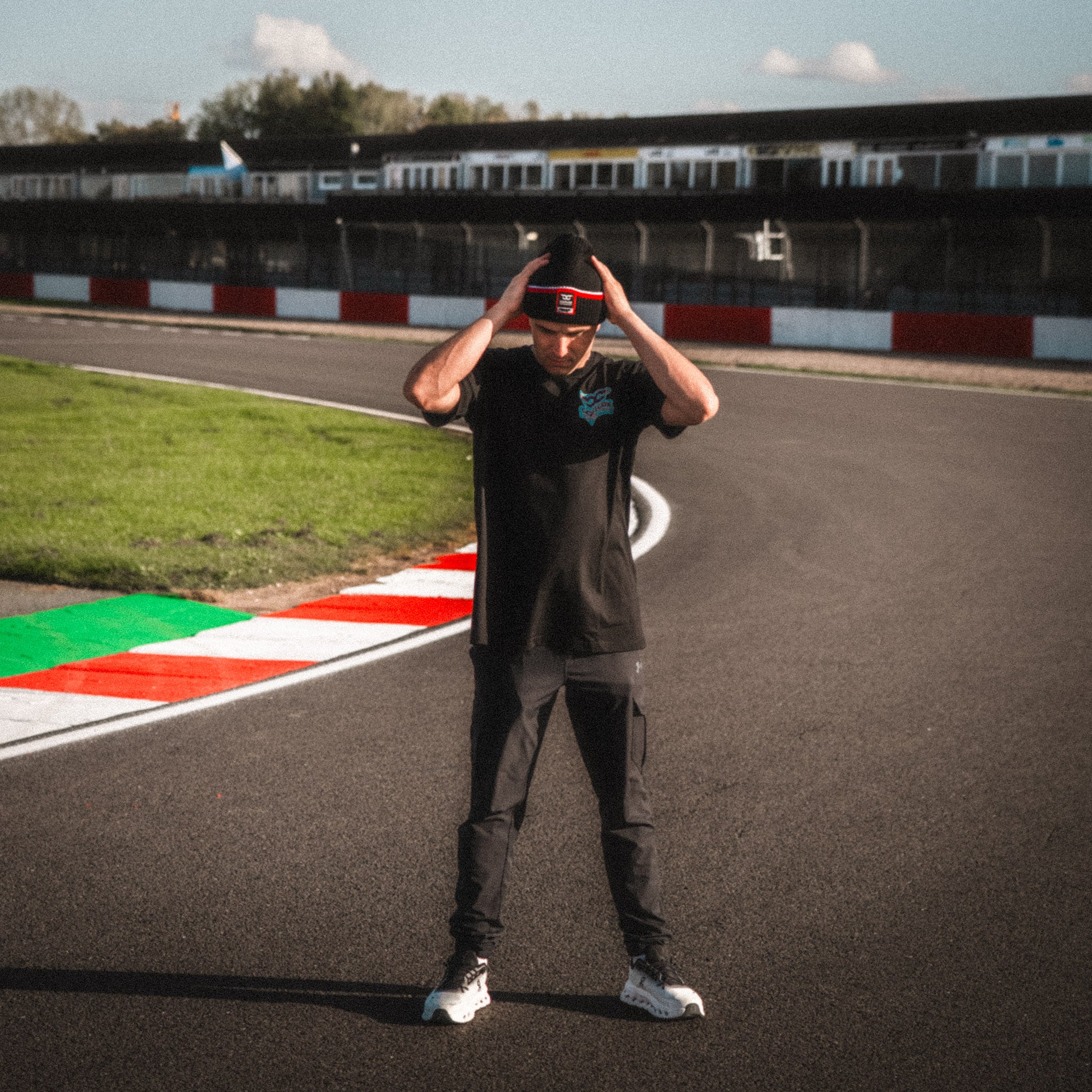 Model wearing the Carl Cox North West 200 Beanie by Uggly & Co, combining motorcycle road racing culture with casual motorsport streetwear.