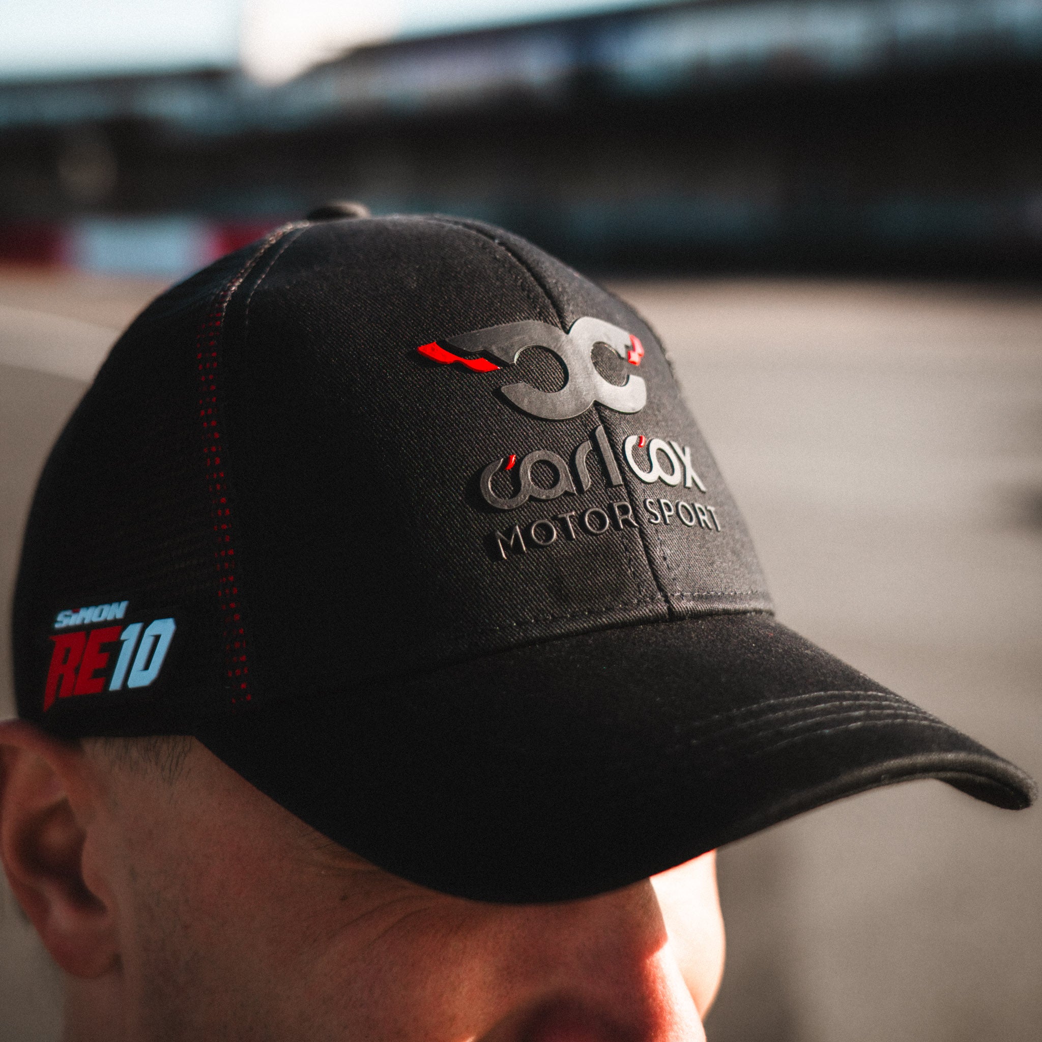 Front view of the Carl Cox Trucker Hat x Alpha Racing & Simon Reid by Uggly & Co, featuring motorsport inspired branding and motorcycle racing style.