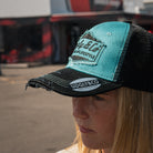 Chloe Jones wearing the turquoise and black Uggly&Co Diamond Trucker Cap