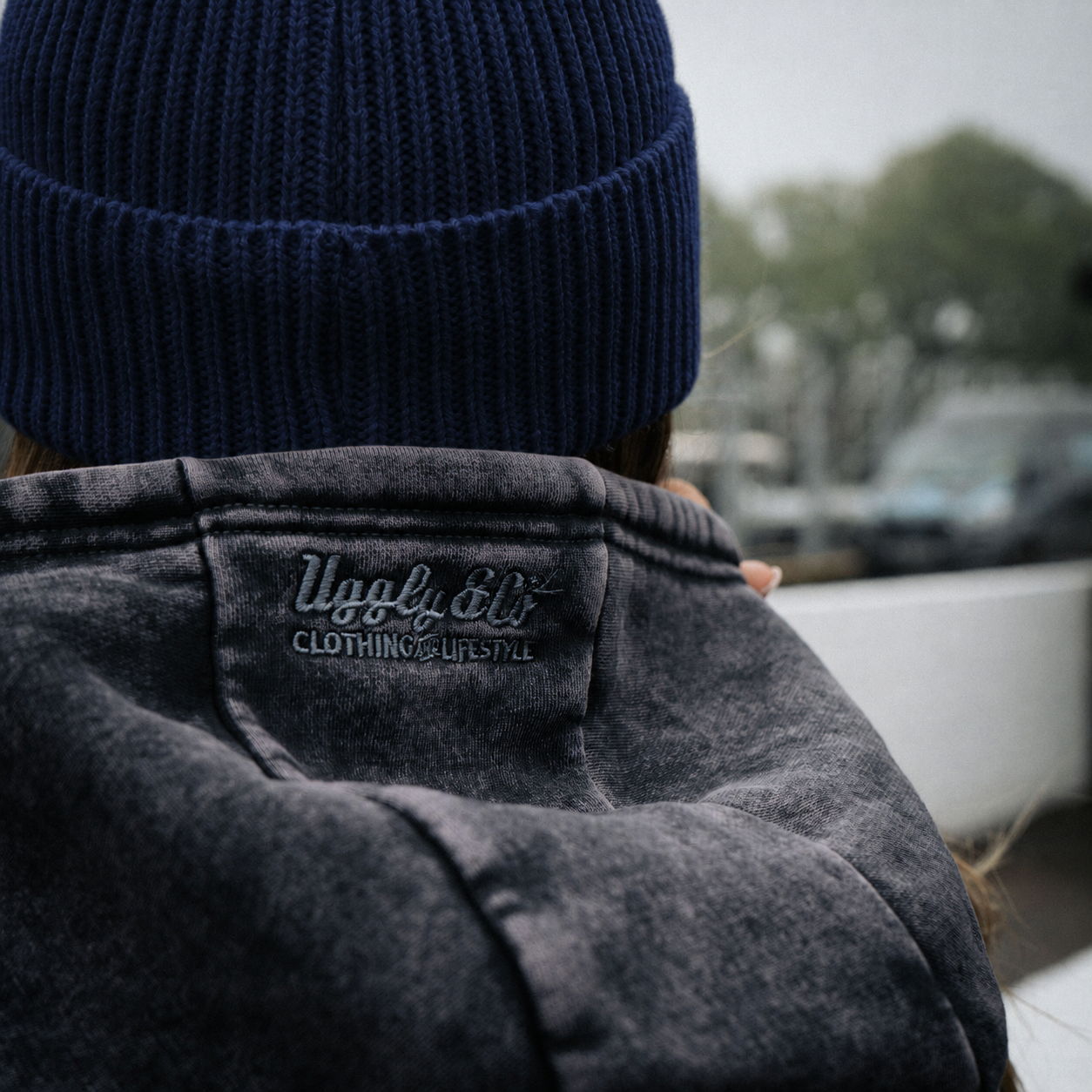 close up shot of a female model wearing a vintage blue hat and acid wash hoodie