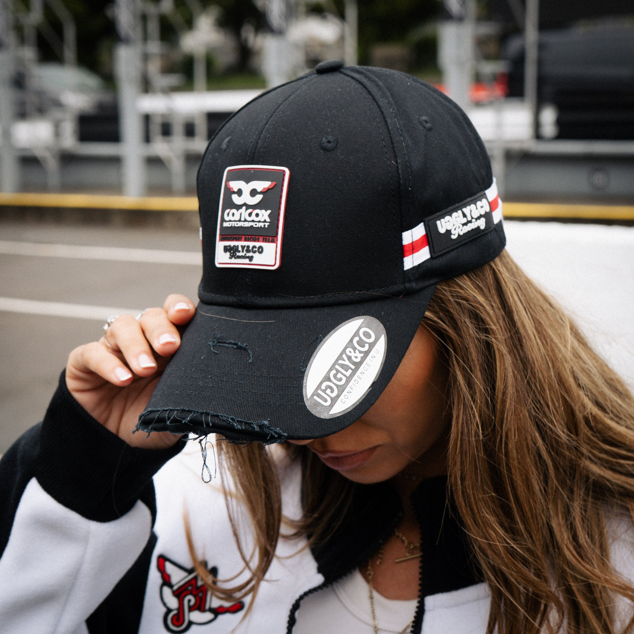 close uo shot of a girl wearing carol cox motorsport cap and track jacket