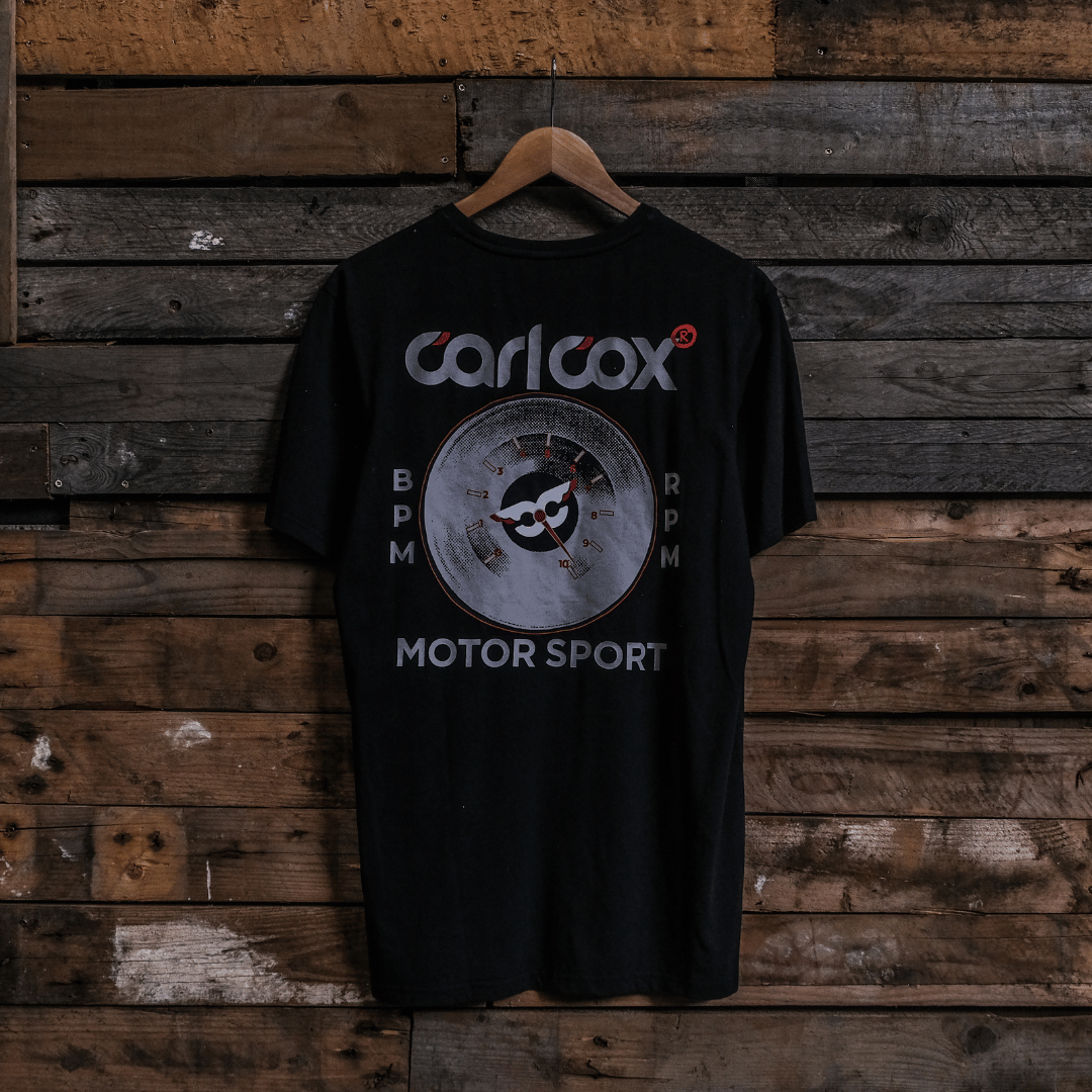 Rear view of a Carl Cox Motorsport BPM RPM black t-shirt on a wooden background