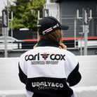 Female model wearing a Carl Cox Motorsport racing jacket in the event paddock.