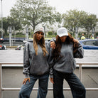 Female model wearing a blue acid wash hoodie, shown from the front.